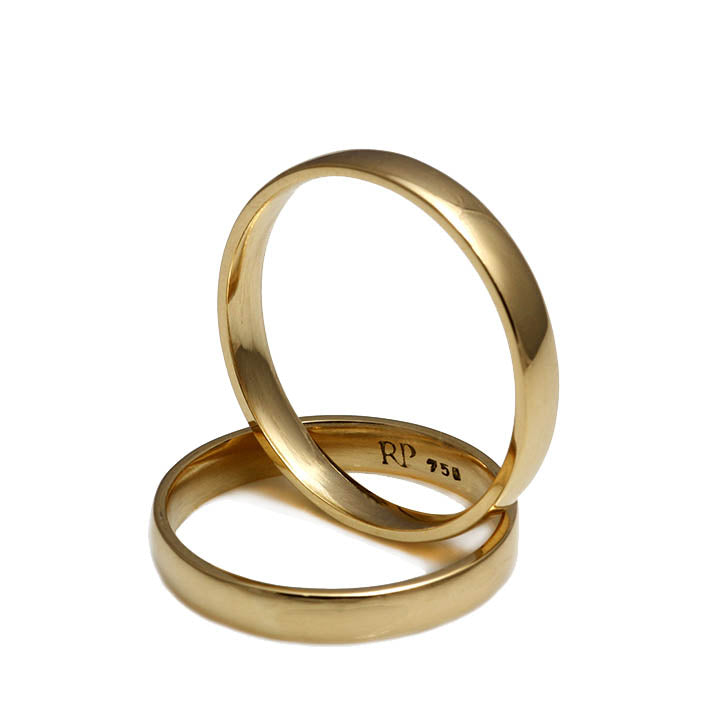 Alianças de casamento na mesa de madeira par de anéis de ouro detalham  faixa larga